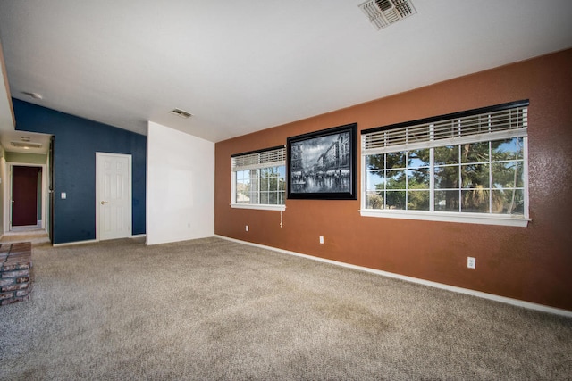 spare room featuring carpet and vaulted ceiling