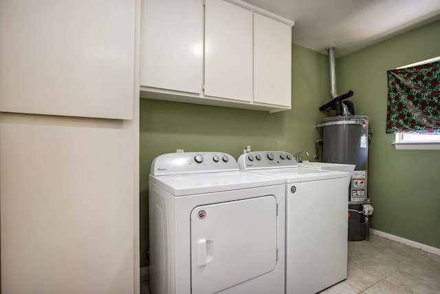 laundry area with light tile patterned floors, gas water heater, washer and clothes dryer, and cabinets