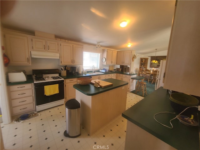 kitchen with light tile patterned flooring, a center island, sink, decorative light fixtures, and white appliances