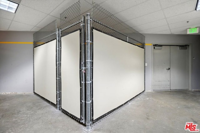 interior space featuring concrete flooring and a drop ceiling