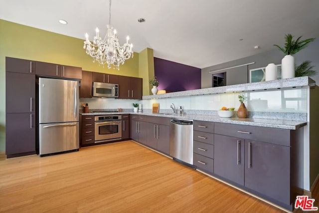 kitchen featuring light hardwood / wood-style flooring, stainless steel appliances, sink, and light stone countertops