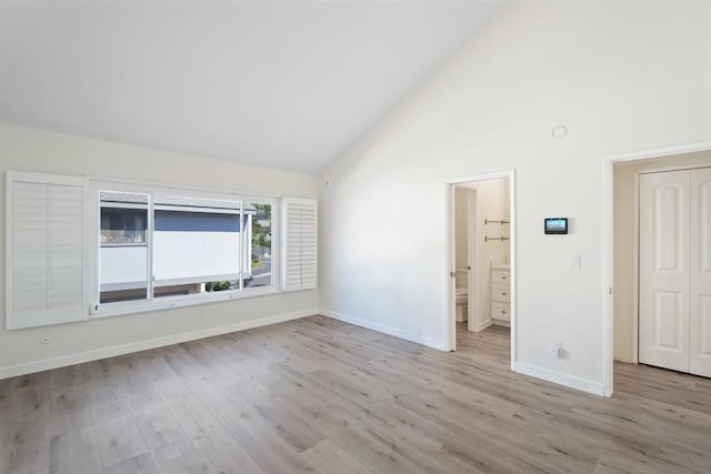 spare room featuring light hardwood / wood-style floors and high vaulted ceiling