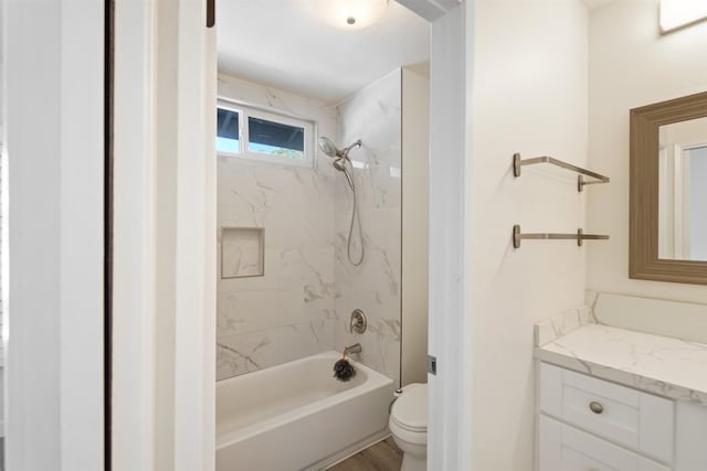 full bathroom featuring hardwood / wood-style flooring, toilet, vanity, and tiled shower / bath