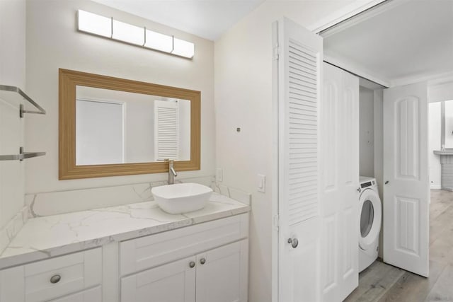 bathroom featuring washer / clothes dryer, wood-type flooring, and vanity