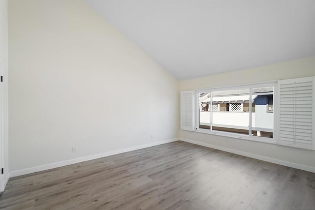 empty room with high vaulted ceiling and hardwood / wood-style floors