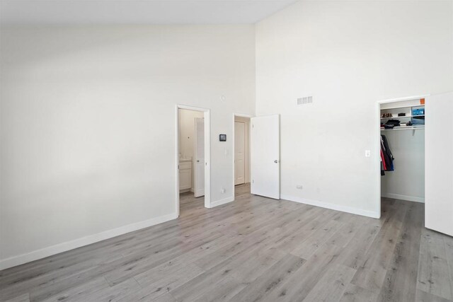 laundry room featuring light hardwood / wood-style floors and a towering ceiling