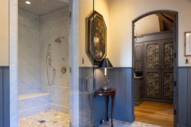 bathroom with wood-type flooring and tiled shower