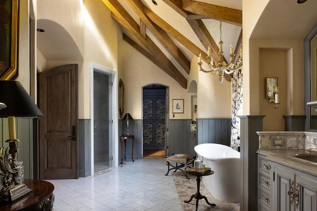 bathroom with beam ceiling, vanity, high vaulted ceiling, and a bathing tub