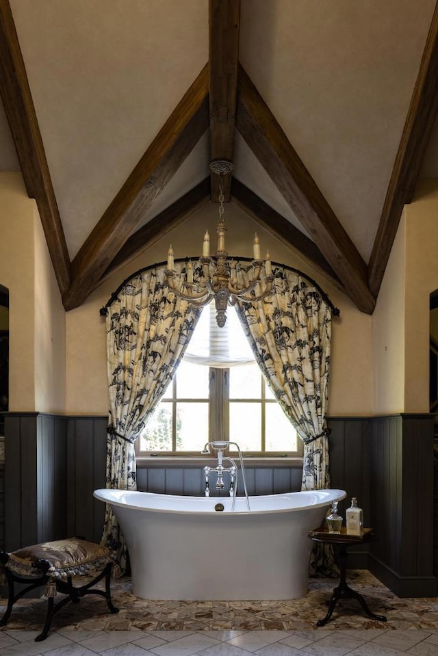 bathroom featuring lofted ceiling with beams, a bathtub, and an inviting chandelier