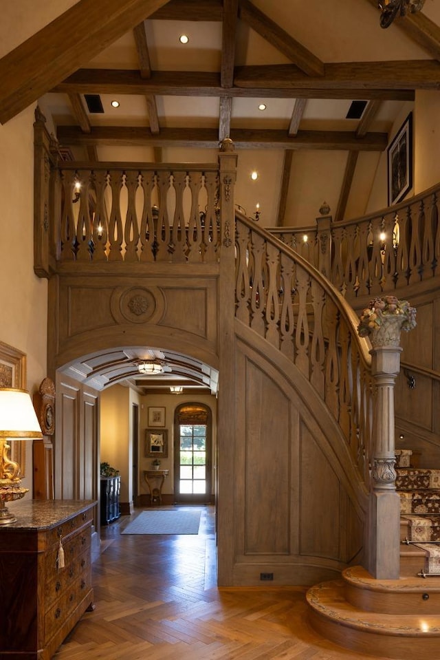 interior space featuring beam ceiling, a high ceiling, and dark parquet flooring