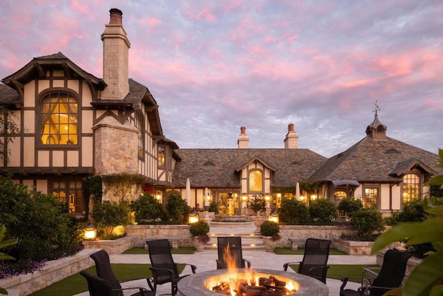 patio terrace at dusk featuring an outdoor fire pit