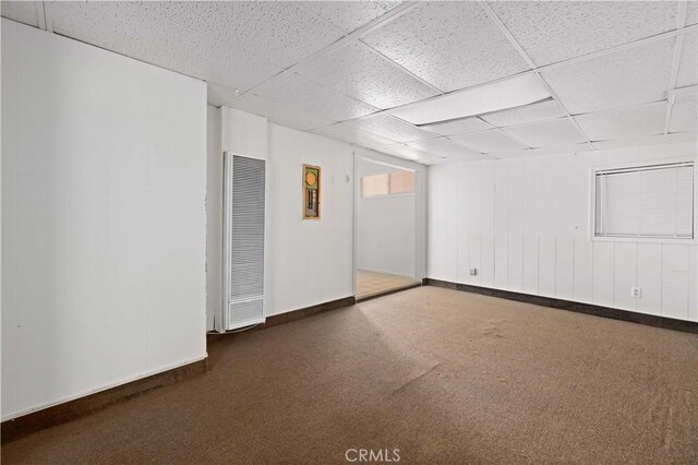 carpeted spare room with a drop ceiling