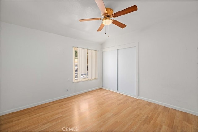 unfurnished bedroom featuring ceiling fan, light wood finished floors, a closet, and baseboards