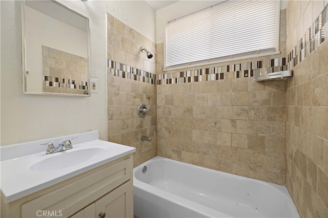 bathroom featuring tiled shower / bath combo and vanity