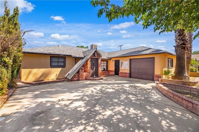 view of front of home featuring roof with shingles, brick siding, stucco siding, a garage, and driveway