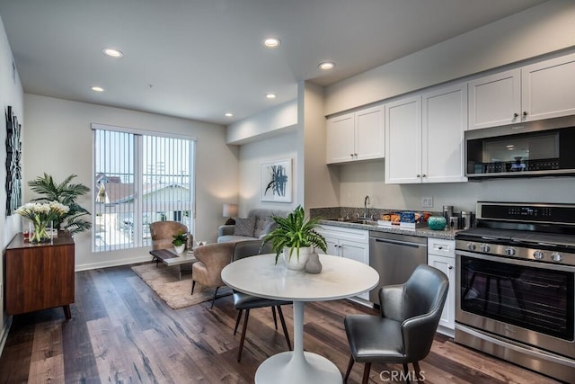 kitchen with white cabinets, dark wood-type flooring, and stainless steel appliances