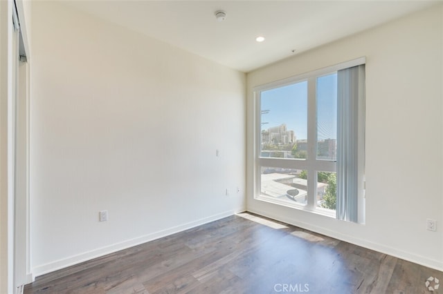 spare room with dark hardwood / wood-style flooring