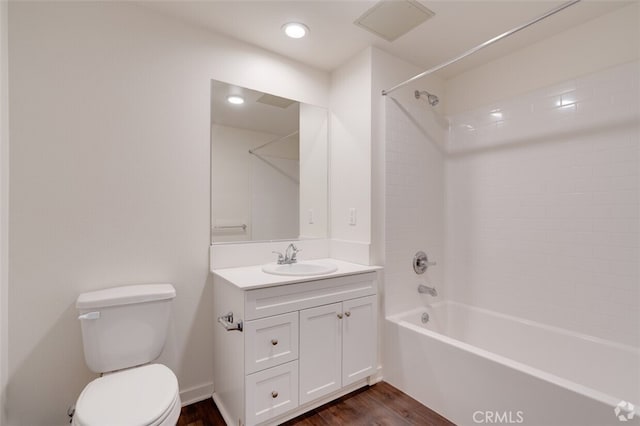 full bathroom featuring  shower combination, vanity, hardwood / wood-style floors, and toilet