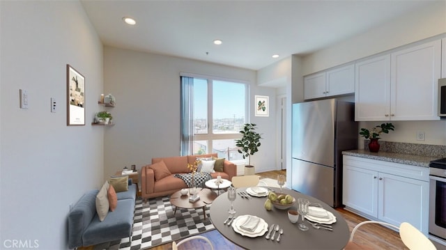 kitchen with appliances with stainless steel finishes, light hardwood / wood-style floors, white cabinetry, and a wealth of natural light