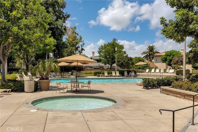 view of swimming pool with a hot tub and a patio