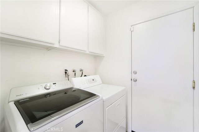 laundry room featuring washing machine and dryer and cabinets