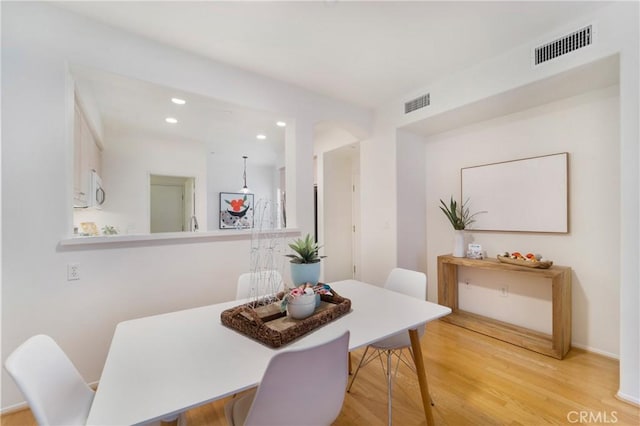 dining space with light hardwood / wood-style flooring