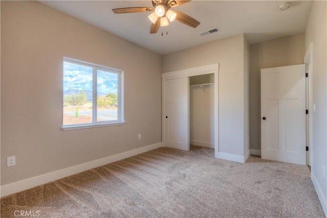 unfurnished bedroom with ceiling fan, a closet, and light carpet