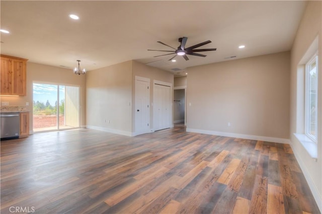 interior space with ceiling fan with notable chandelier and dark hardwood / wood-style floors