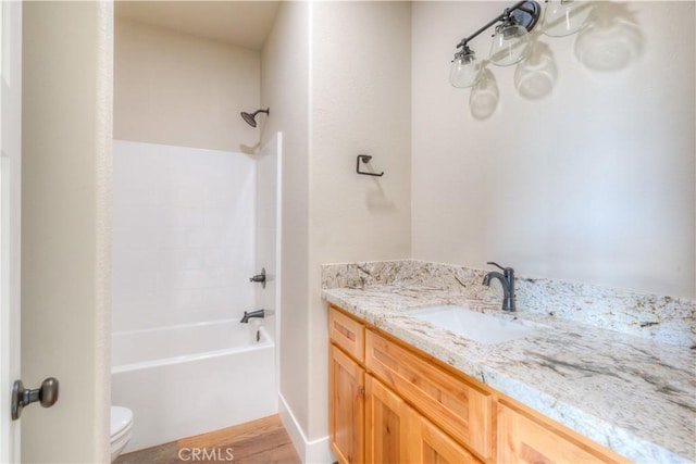 full bathroom featuring toilet, vanity, hardwood / wood-style flooring, and shower / bathtub combination