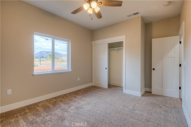 unfurnished bedroom featuring ceiling fan, a closet, and light carpet