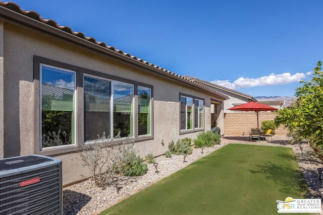 view of home's exterior with a yard and cooling unit