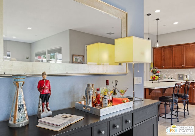 kitchen featuring pendant lighting, decorative backsplash, and a breakfast bar