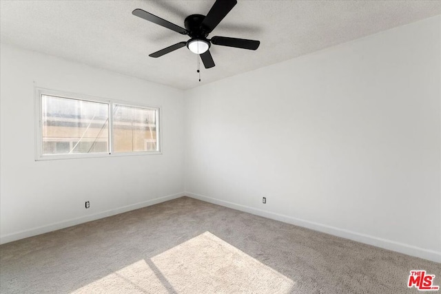 carpeted spare room featuring ceiling fan and a textured ceiling