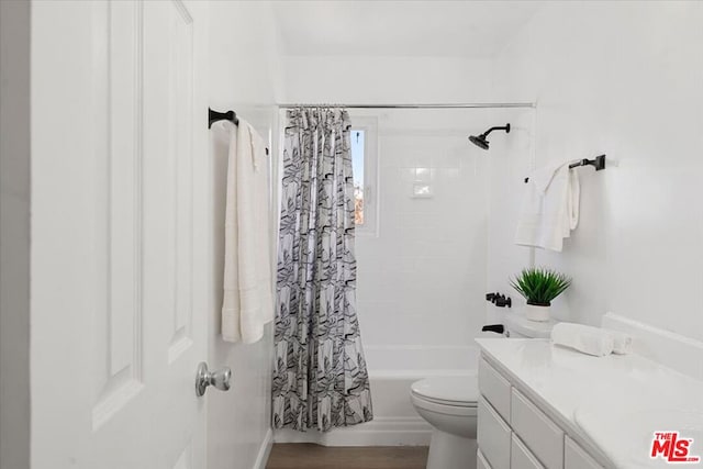 full bathroom featuring toilet, hardwood / wood-style flooring, vanity, and shower / tub combo with curtain