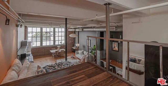 basement with hardwood / wood-style floors and brick wall