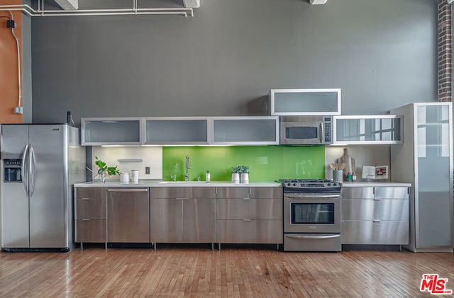 kitchen featuring appliances with stainless steel finishes, light wood-type flooring, and sink