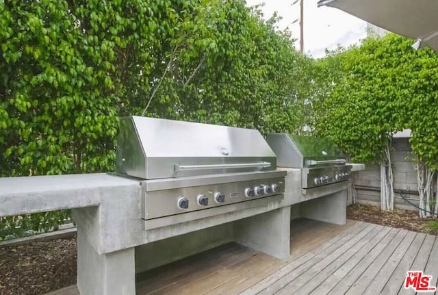 wooden deck featuring area for grilling and a grill