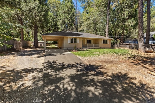 view of front facade with an attached carport, fence, and driveway