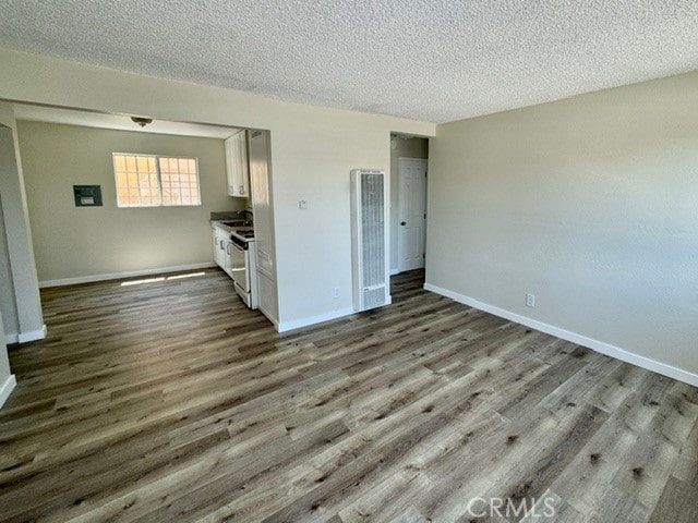 unfurnished living room with light wood-type flooring and a textured ceiling