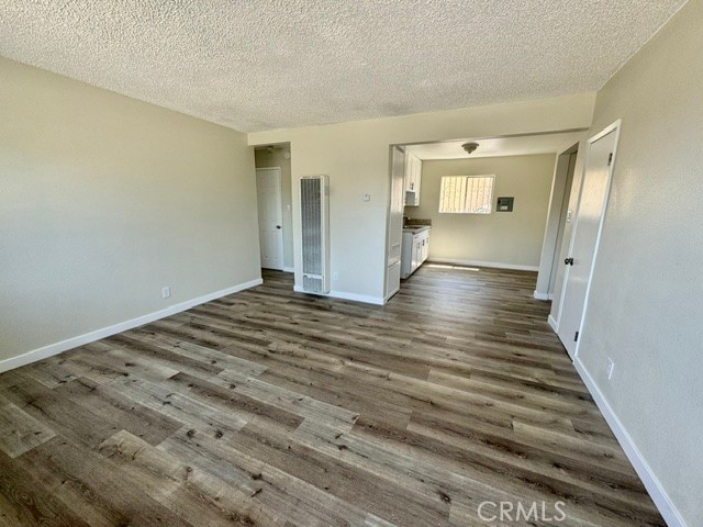 unfurnished room with a textured ceiling and dark hardwood / wood-style flooring