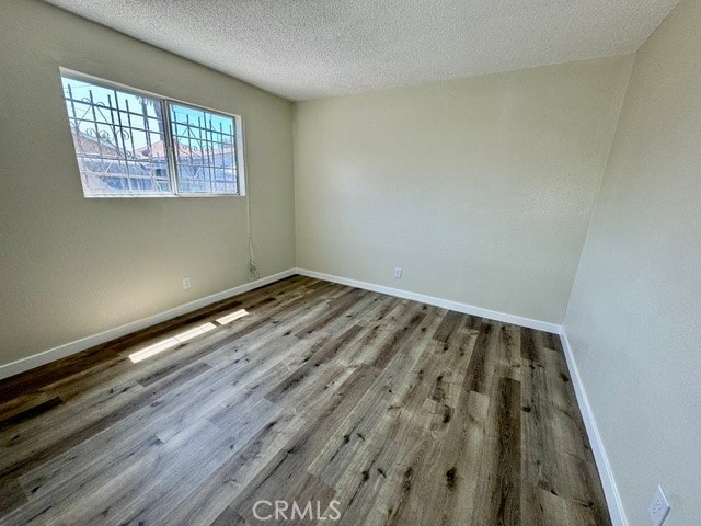 empty room with a textured ceiling and hardwood / wood-style floors