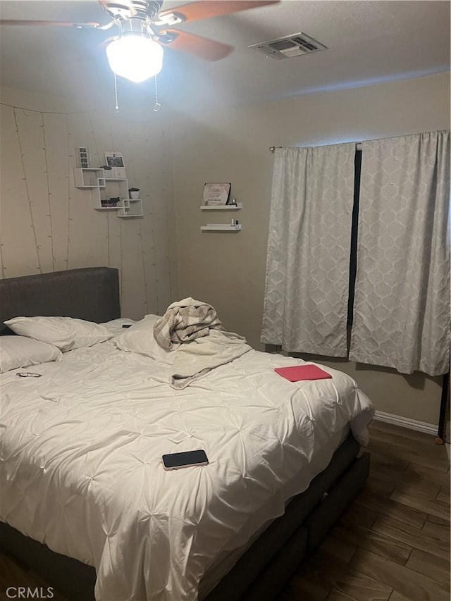 bedroom with dark hardwood / wood-style flooring and ceiling fan