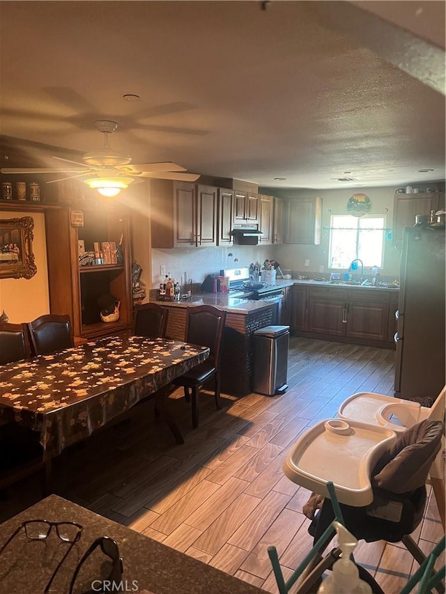 kitchen featuring hardwood / wood-style floors, ceiling fan, a textured ceiling, and appliances with stainless steel finishes