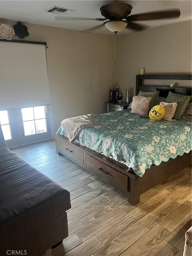 bedroom with light hardwood / wood-style flooring and ceiling fan