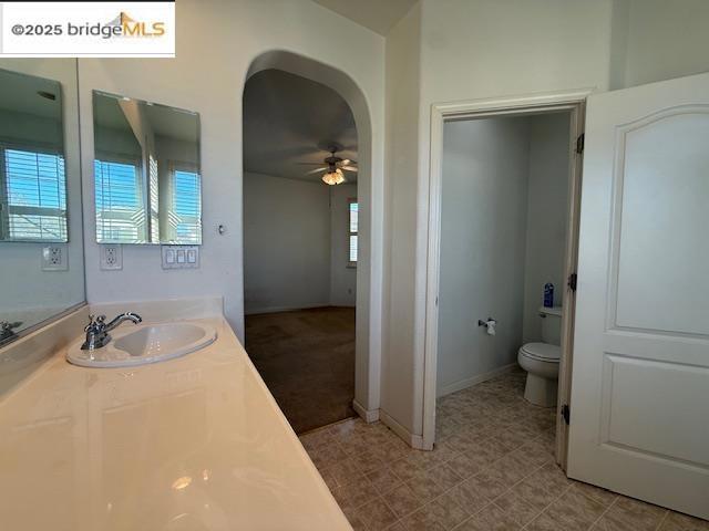 bathroom featuring ceiling fan, vanity, and toilet