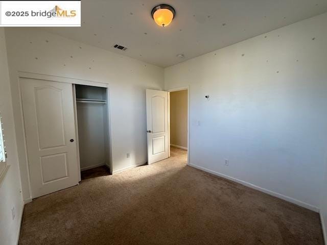 unfurnished bedroom with carpet floors and a closet