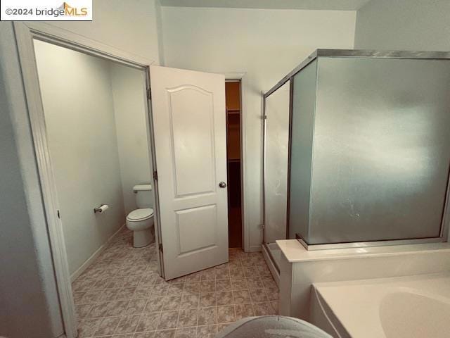 bathroom featuring toilet and separate shower and tub