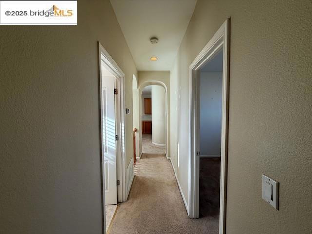 corridor featuring light colored carpet