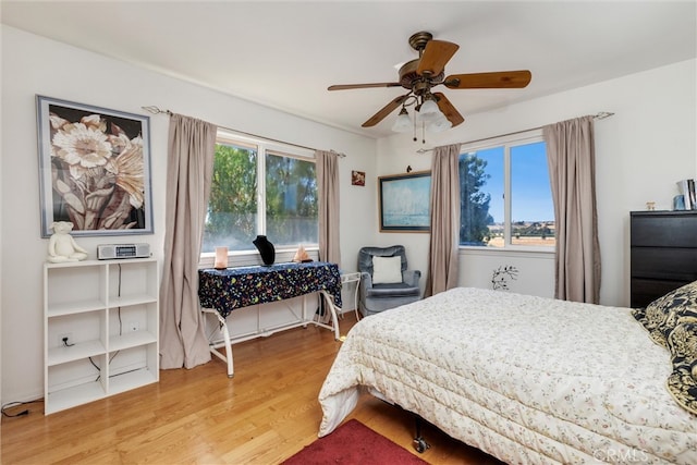 bedroom with multiple windows, hardwood / wood-style floors, and ceiling fan