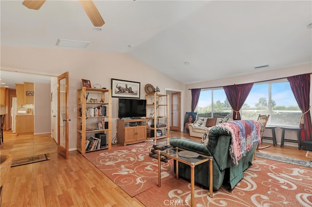 living room featuring vaulted ceiling, ceiling fan, and light hardwood / wood-style flooring